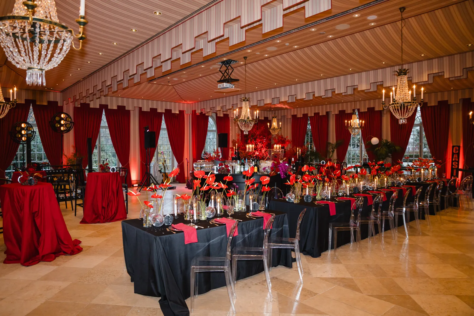 Gala-Dinner mit roten und schwarzen Tischdecken und Kronleuchtern in einer Eventlocation