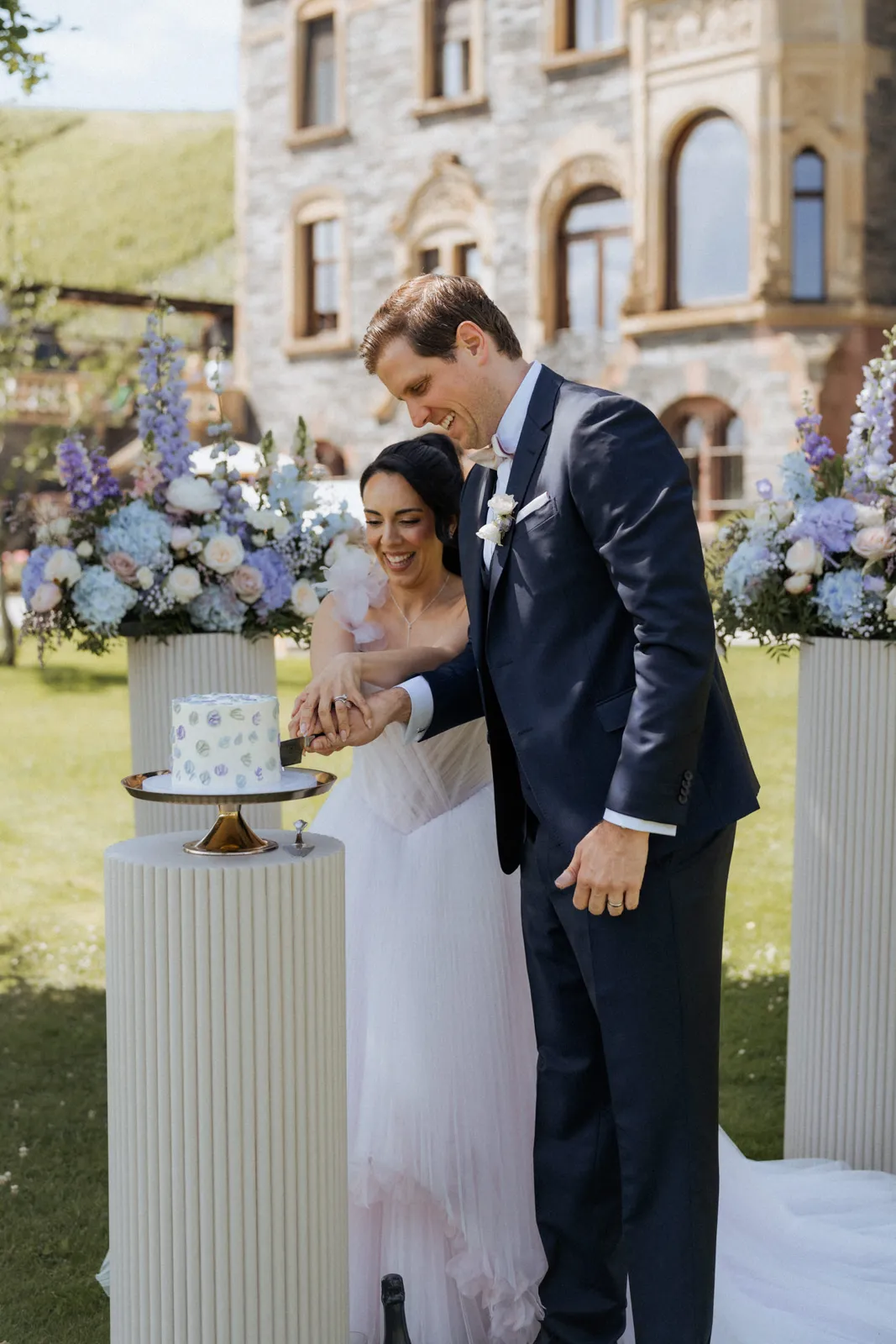 Brautpaar schneidet Hochzeitstorte vor floraler Deko – Eventdesign von vonRock Events